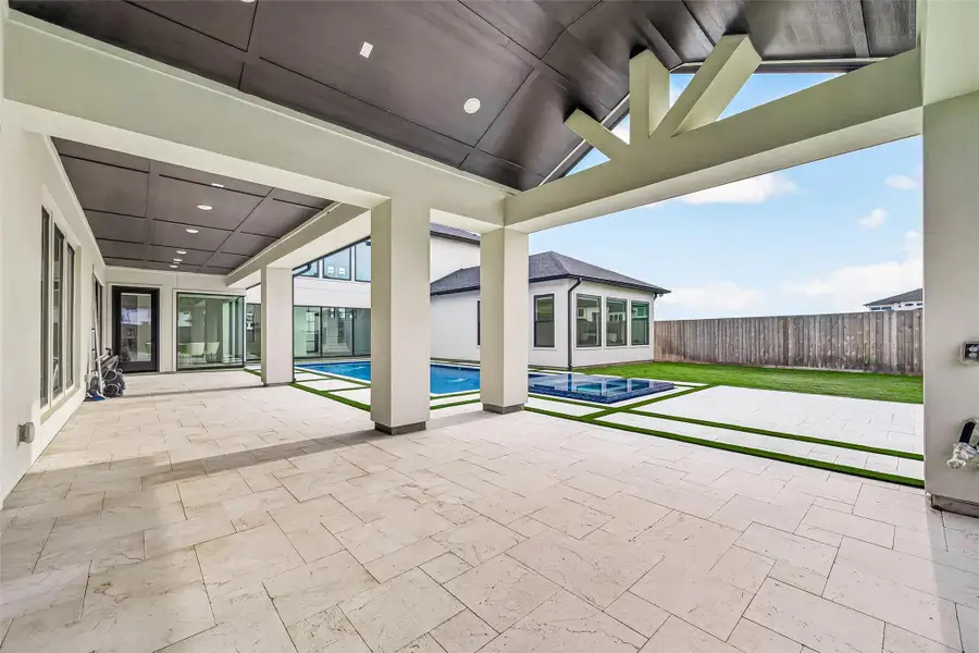 The oversized covered patio is pre-plumbed and ready for a future outdoor kitchen, while built-in sound wiring, extensive flood lighting, rain gutters, and sprinkler system add convenience and functionality.