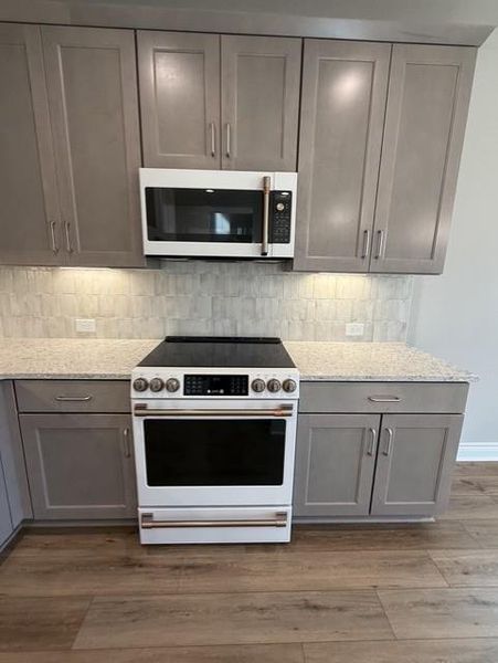 Modern kitchen with granite counters, sleek cabinetry, and integrated appliances awaits culinary creations. Modern kitchen with granite counters, sleek cabinetry, and integrated appliances awaits culinary creations.