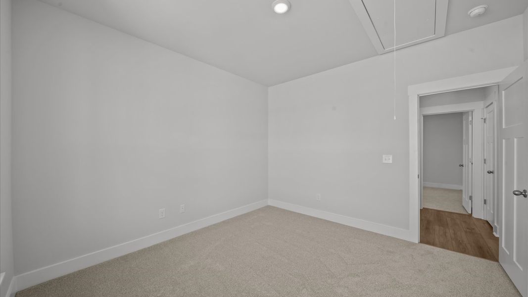 Bright and serene bedroom with comfortable carpeted flooring and large windows for vibrant light