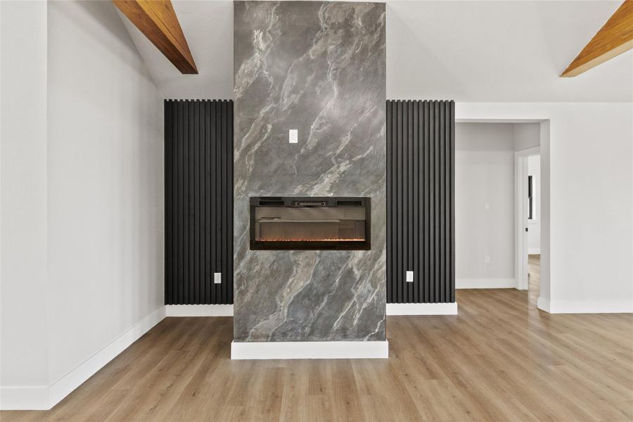 The dining area showcases a dramatic feature wall with a sleek electric fireplace, creating a stunning focal point that can be enjoyed from nearly every corner of the home's open-concept living spaces.