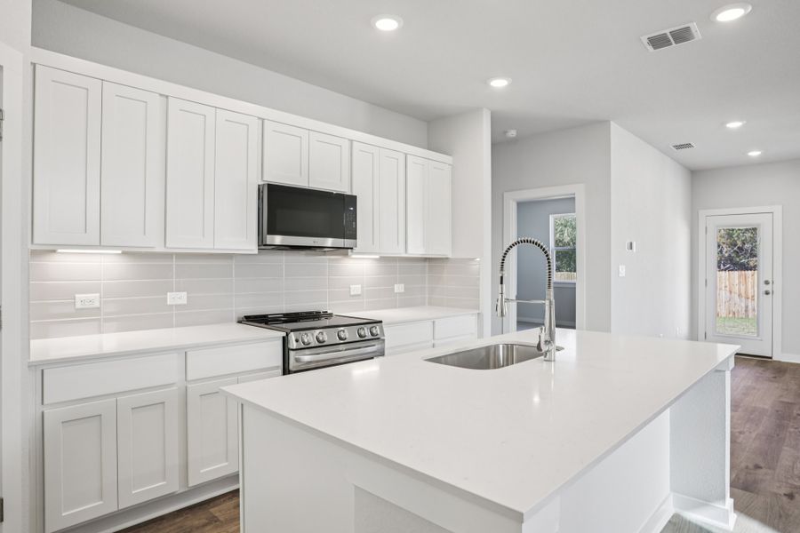 A kitchen with white cabinets.