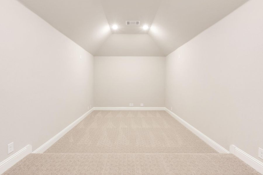Empty room with vaulted ceiling, recessed lighting, and beige carpet on white walls