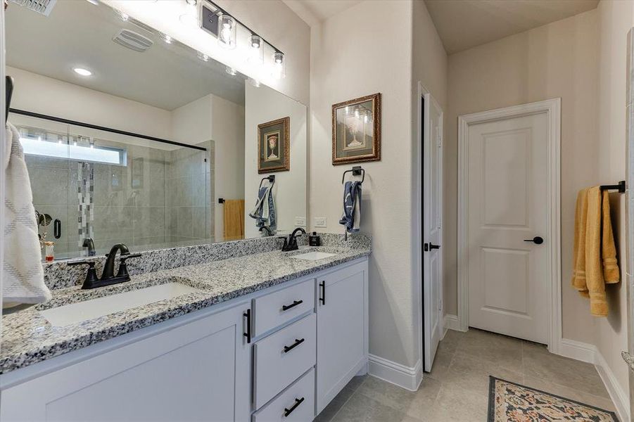 The spa-like primary bath features granite countertops, dual sinks, overized shower with built in bench and walk in closet The spa-like primary bath features granite countertops, dual sinks, overized shower with built in bench and walk in closet