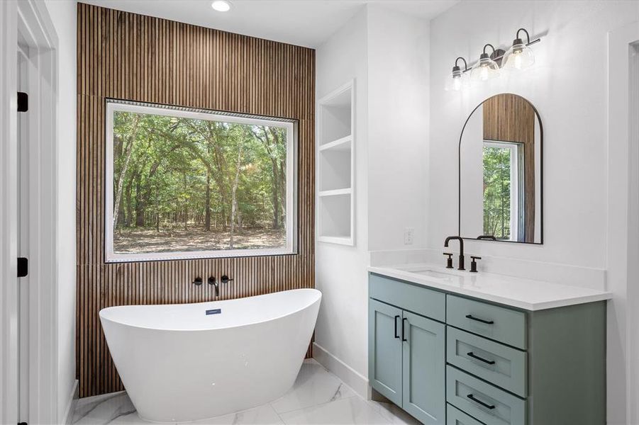 Full bathroom with vanity, a freestanding tub, light marble finish flooring, recessed lighting, and wood walls Full bathroom with vanity, a freestanding tub, light marble finish flooring, recessed lighting, and wood walls