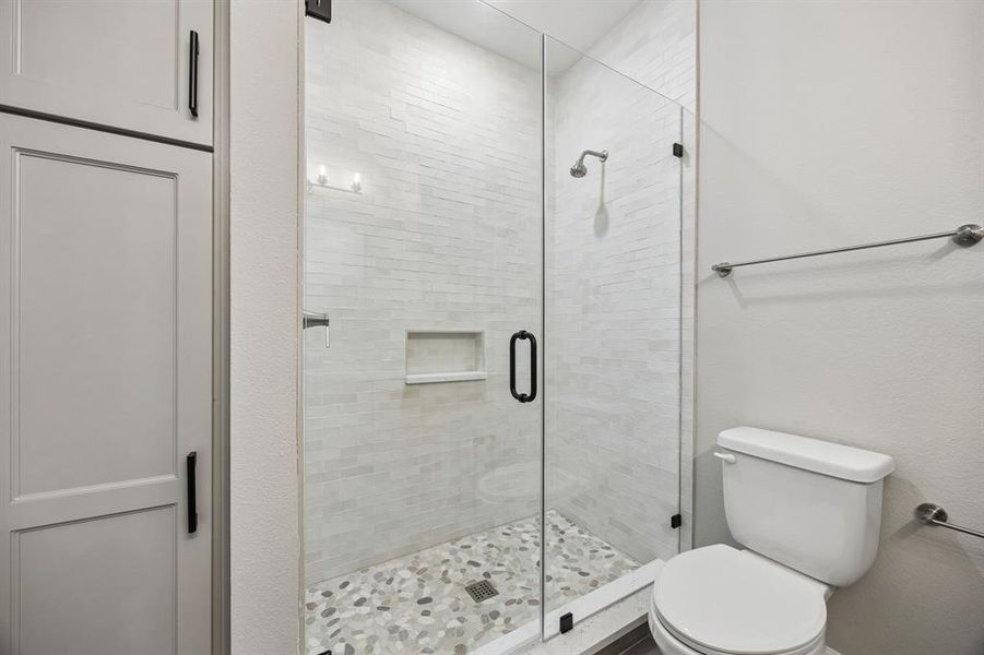 Full bathroom with toilet and a shower stall Full bathroom with toilet and a shower stall