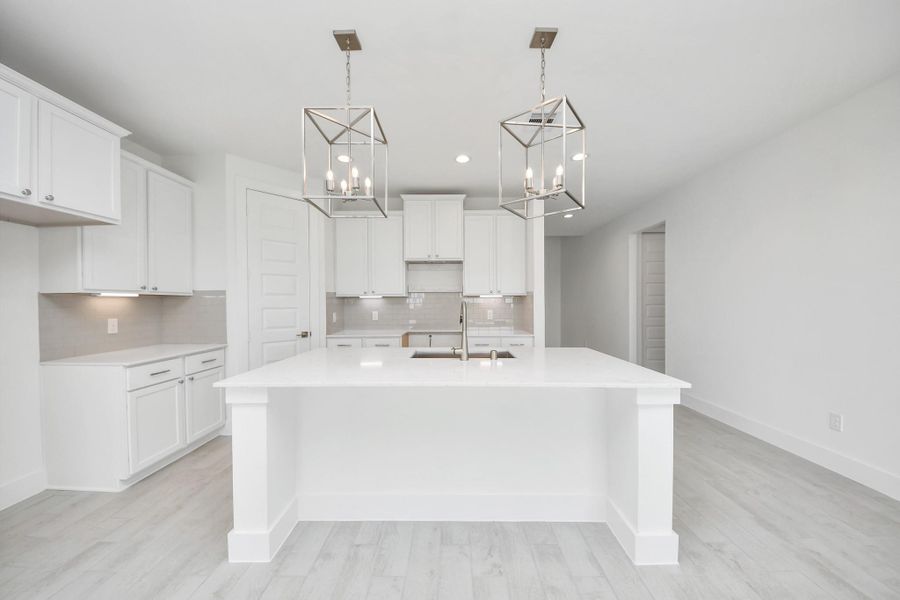 The kitchen is a culinary haven, featuring granite countertops, a tile backsplash, stainless steel appliances, 42” upper cabinets, and undercabinet lighting.