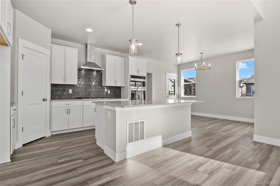 Kitchen equipped with quartz countertops, a center island, crown moulding, and stainless appliances