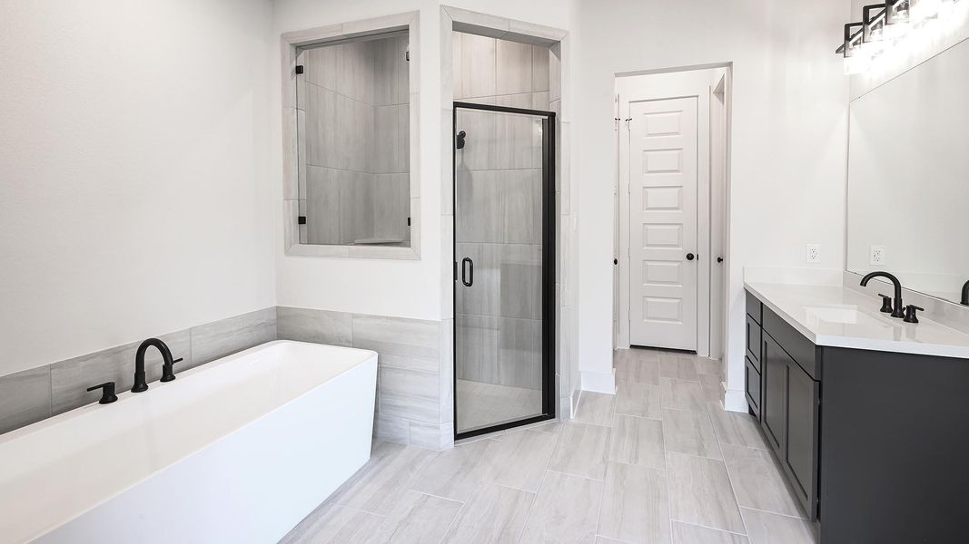 Bathroom with vanity, a soaking tub, and a stall shower
