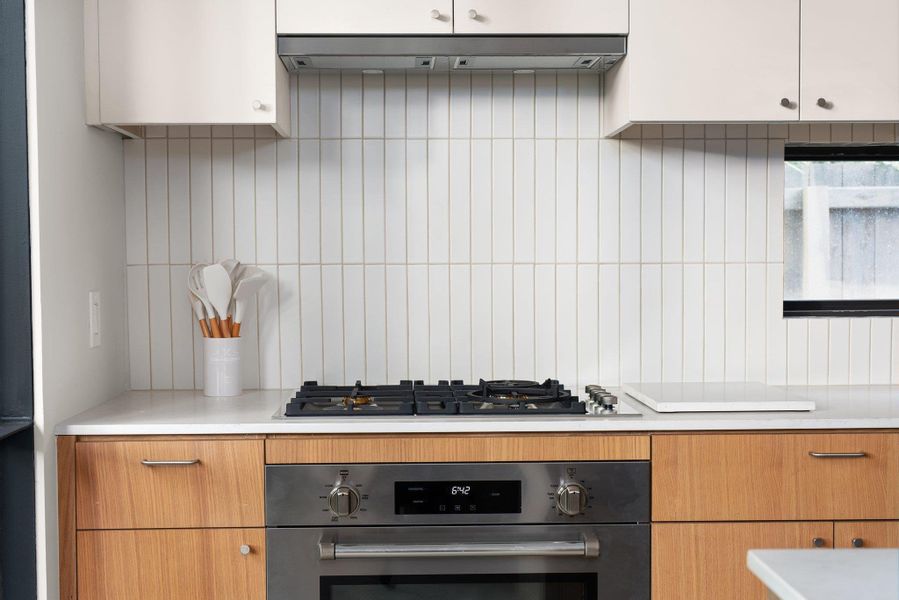 Kitchen featuring stainless steel appliances, light countertops, and tasteful backsplash Kitchen featuring stainless steel appliances, light countertops, and tasteful backsplash