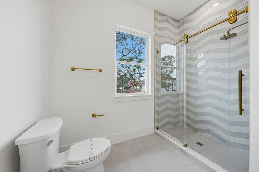 Secondary bathroom (#1): This beautifully appointed en-suite bathroom reflects the home's commitment to quality and cohesive design. Every detail has been curated to provide a spa-like experience with a fresh, modern aesthetic.