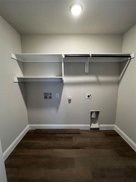 Clothes washing area with electric dryer hookup, hookup for a gas dryer, dark hardwood / wood-style flooring, and washer hookup