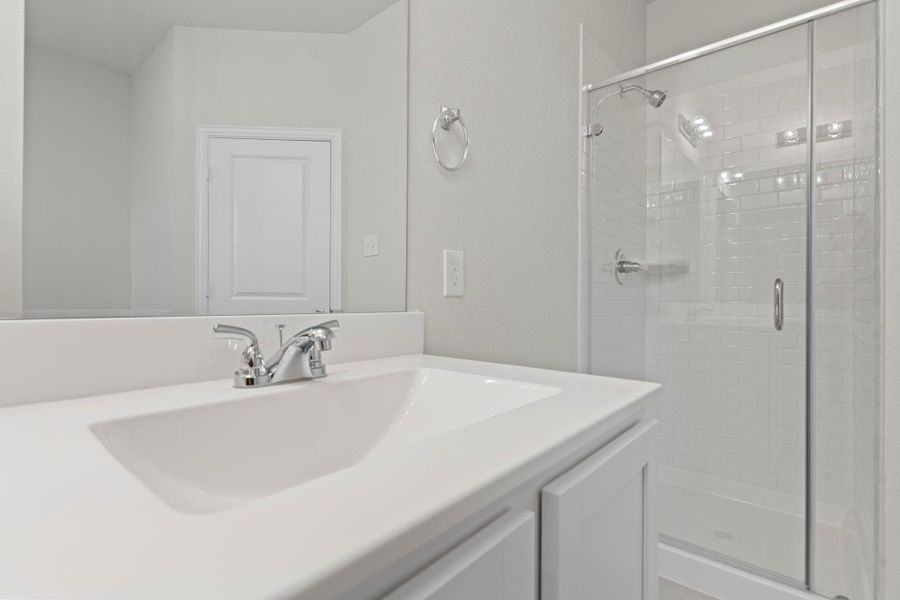 A closer look at the glass-enclosed shower reveals a modern, streamlined finish paired with sleek fixtures. Together with the large vanity, this space combines comfort, functionality, and everyday luxury.  With the Tankless Water Heater you will never run out of hot water! This primary bathroom has it all!