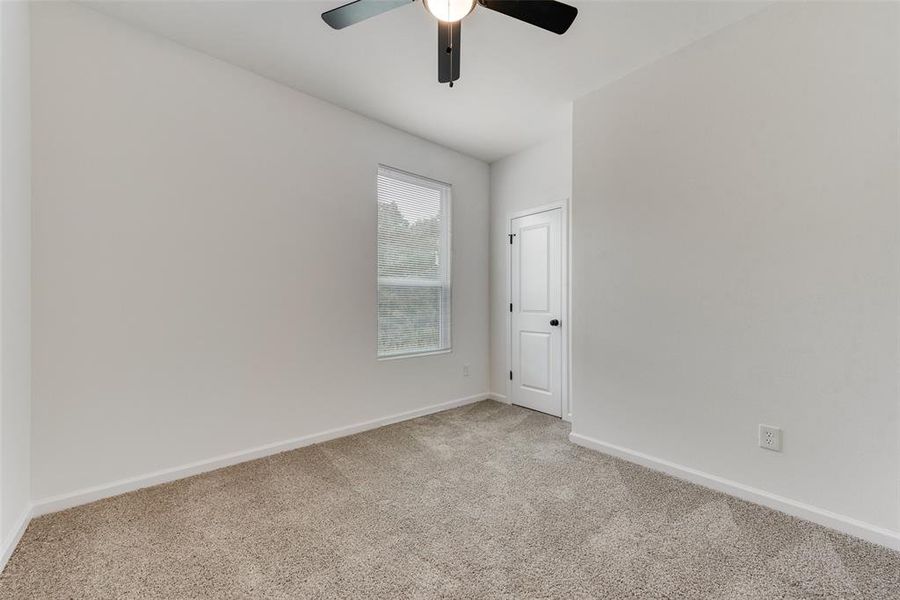 Carpeted empty room featuring ceiling fan