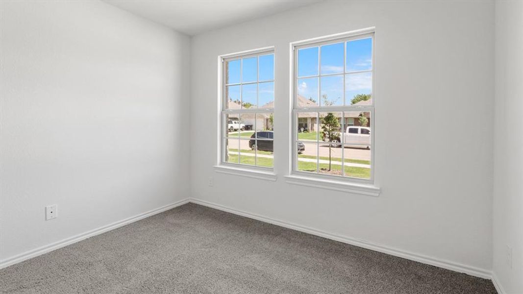 Bright interior room featuring a neutral color palette, two large windows with grid patterns, white trim, and gray carpet