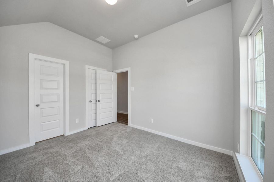 Inviting guest suite adorned with modern charm. The room features elegant 5-panel doors with sleek, contemporary hardware that adds a touch of sophistication. Sink your feet into the plush, fluffy carpet that invites comfort and warmth. Large windows flood the space with an abundance of natural light, framed by privacy blinds that offer the perfect balance between openness and seclusion. Sample photo of completed home with similar floor plan. Actual colors and selections may vary. Inviting guest suite adorned with modern charm. The room features elegant 5-panel doors with sleek, contemporary hardware that adds a touch of sophistication. Sink your feet into the plush, fluffy carpet that invites comfort and warmth. Large windows flood the space with an abundance of natural light, framed by privacy blinds that offer the perfect balance between openness and seclusion. Sample photo of completed home with similar floor plan. Actual colors and selections may vary.