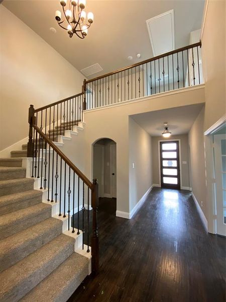 Impressive cathedral ceiling in entry with wrought iron spindles & chandelier Impressive cathedral ceiling in entry with wrought iron spindles & chandelier