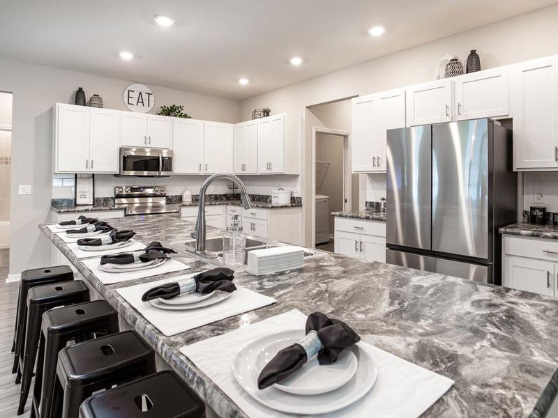 You will love the beautiful, open kitchen with an oversized counter-height island that can easily seat up to six - Summerlyn ll home plan by Highland Homes