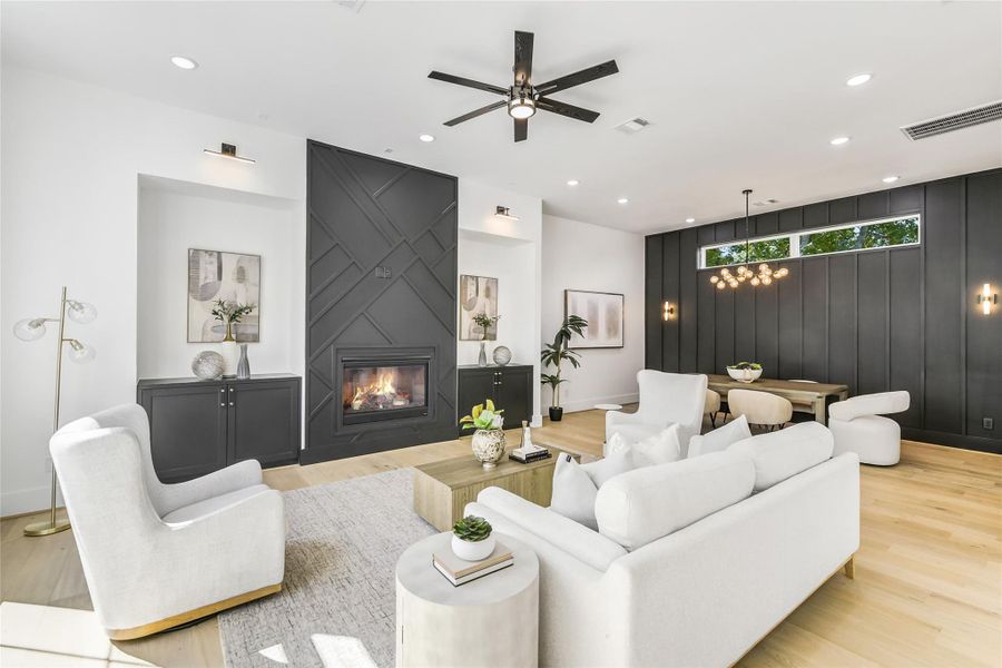 Thoughtfully designed open layout transitions seamlessly from the living area to the dining room, perfect for entertaining. Custom millwork fireplace wall, matching built-in cabinets, and a statement chandelier highlight the home’s architectural precision. The cohesive palette of soft neutrals and bold charcoal accents creates a modern yet timeless atmosphere. Thoughtfully designed open layout transitions seamlessly from the living area to the dining room, perfect for entertaining. Custom millwork fireplace wall, matching built-in cabinets, and a statement chandelier highlight the home’s architectural precision. The cohesive palette of soft neutrals and bold charcoal accents creates a modern yet timeless atmosphere.