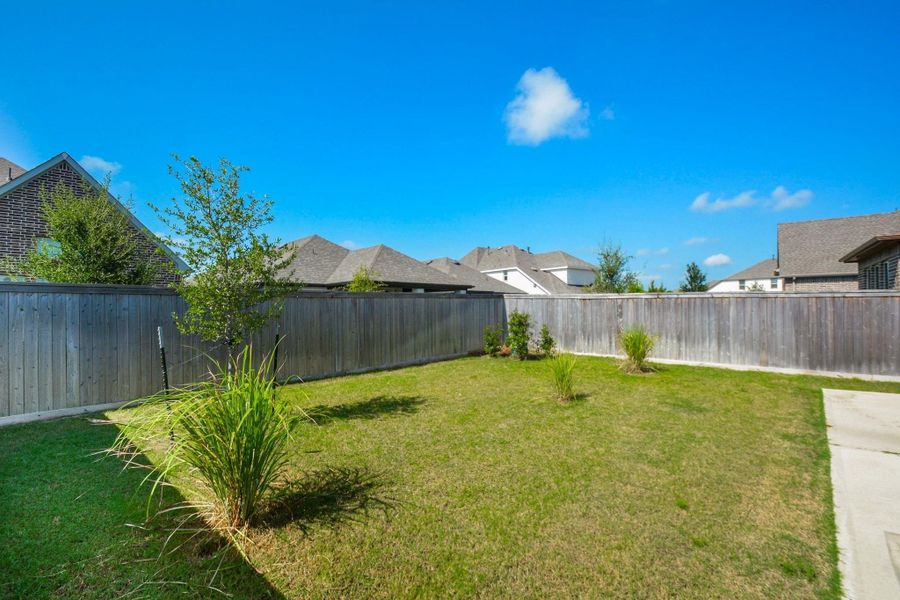 The spacious backyard highlights the generous outdoor living space waiting to be enjoyed. Whether hosting friends, playing with pets, or simply unwinding under the Texas sky, this backyard offers the freedom to enjoy every moment outdoors.