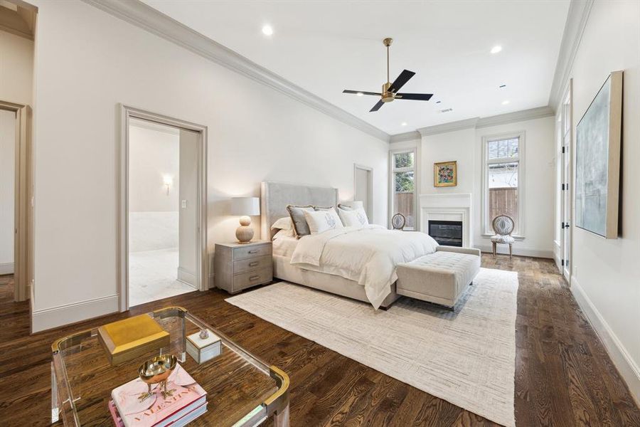 Another view of the primary bedroom highlights its cozy fireplace, natural light, and convenient double-sided access to the bathroom.