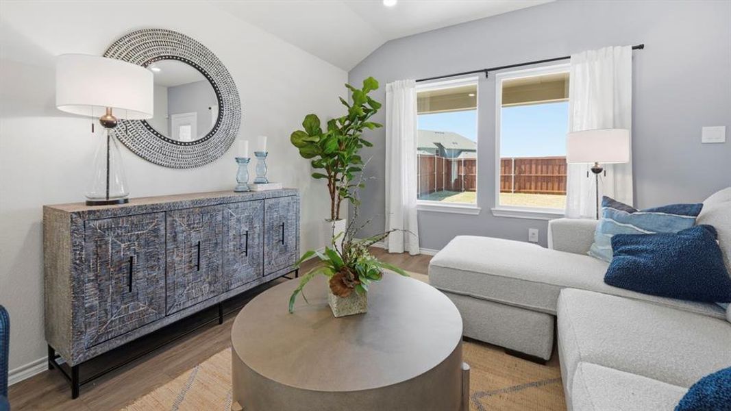 The living area features light-colored walls, a large window providing views of the backyard, and hardwood floors