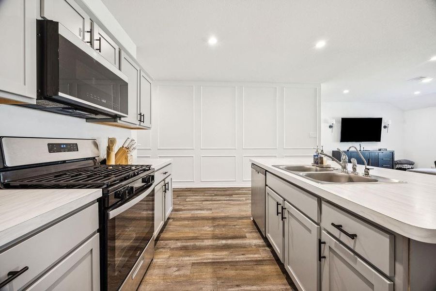 Modern kitchen featuring sleek cabinetry, stainless steel appliances, and a spacious island with dual sinks, perfect for entertaining and everyday living. Modern kitchen featuring sleek cabinetry, stainless steel appliances, and a spacious island with dual sinks, perfect for entertaining and everyday living.