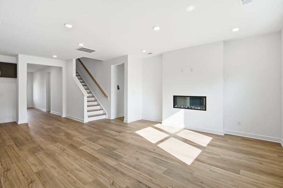 A large empty room with a staircase. A large empty room with a staircase.