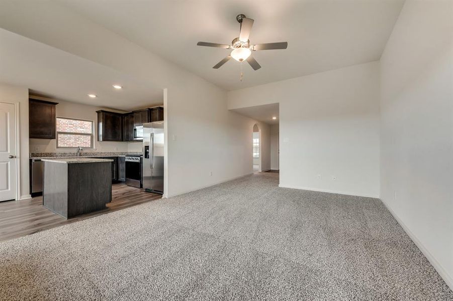 Kitchen with dark brown cabinets, carpet, plenty of natural light, and a kitchen island