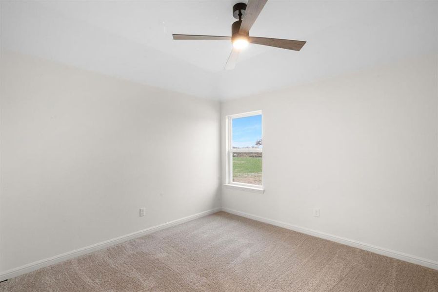 Spare room featuring carpet floors and ceiling fan Spare room featuring carpet floors and ceiling fan