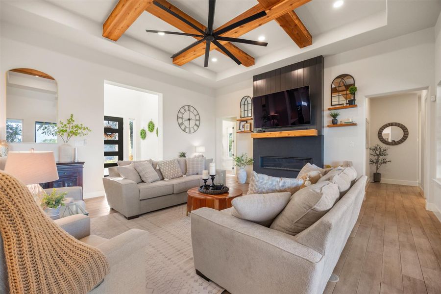 Living room featuring coffered ceiling, a fireplace, beamed ceiling, and light wood-type flooring Living room featuring coffered ceiling, a fireplace, beamed ceiling, and light wood-type flooring