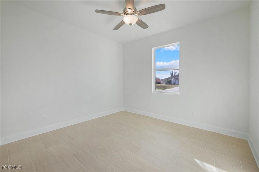 Empty room featuring wood finish floors and ceiling fan Empty room featuring wood finish floors and ceiling fan