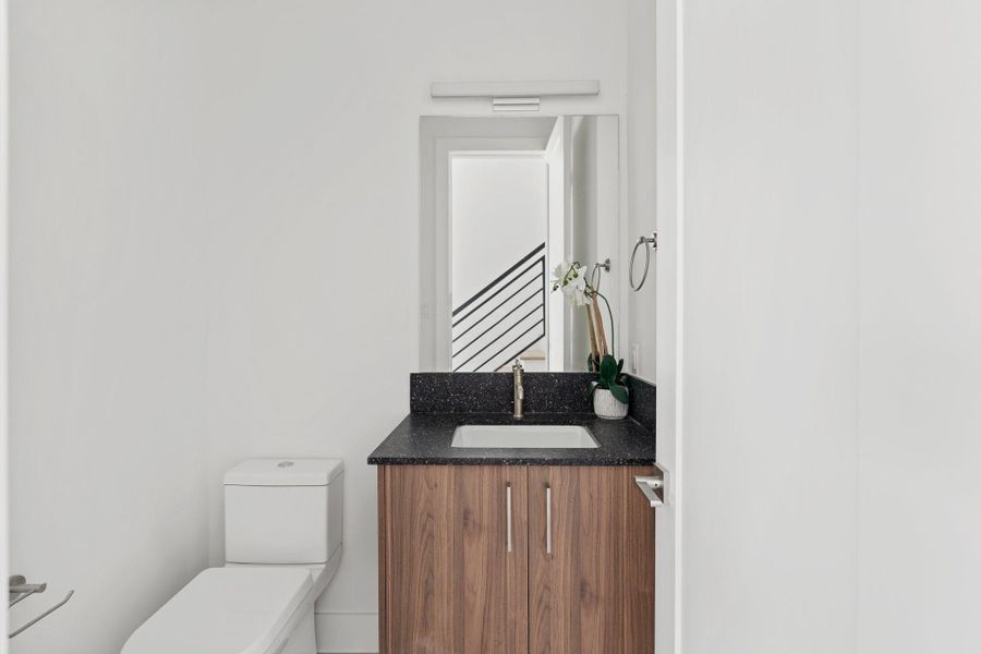 Elegant powder room featuring quartz countertops, custom cabinetry by GoBravura, and refined finishes. Elegant powder room featuring quartz countertops, custom cabinetry by GoBravura, and refined finishes.