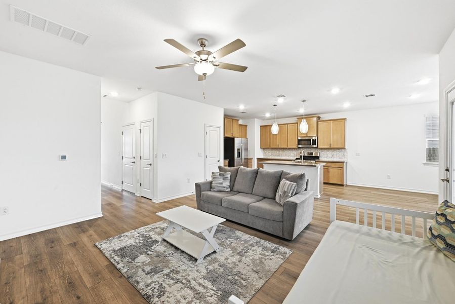 Living area with dark wood-type flooring, a ceiling fan, and recessed lighting