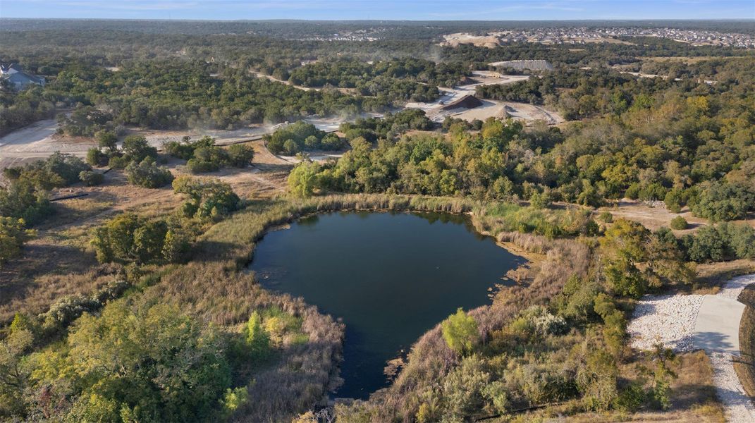 Aerial view of property's location with a forest and a large body of water
