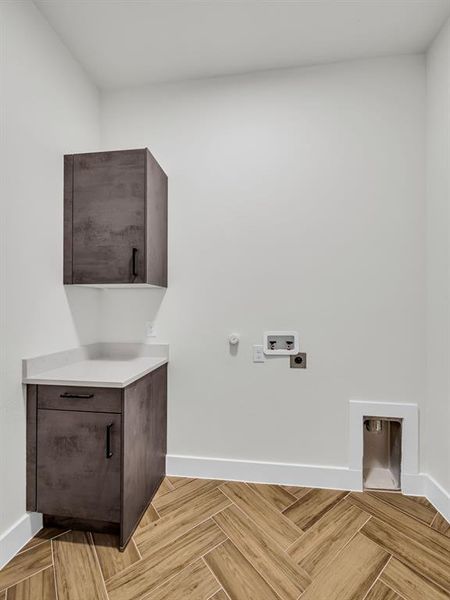 Laundry area with hookup for a gas dryer, electric dryer hookup, washer hookup, cabinets, and light parquet flooring