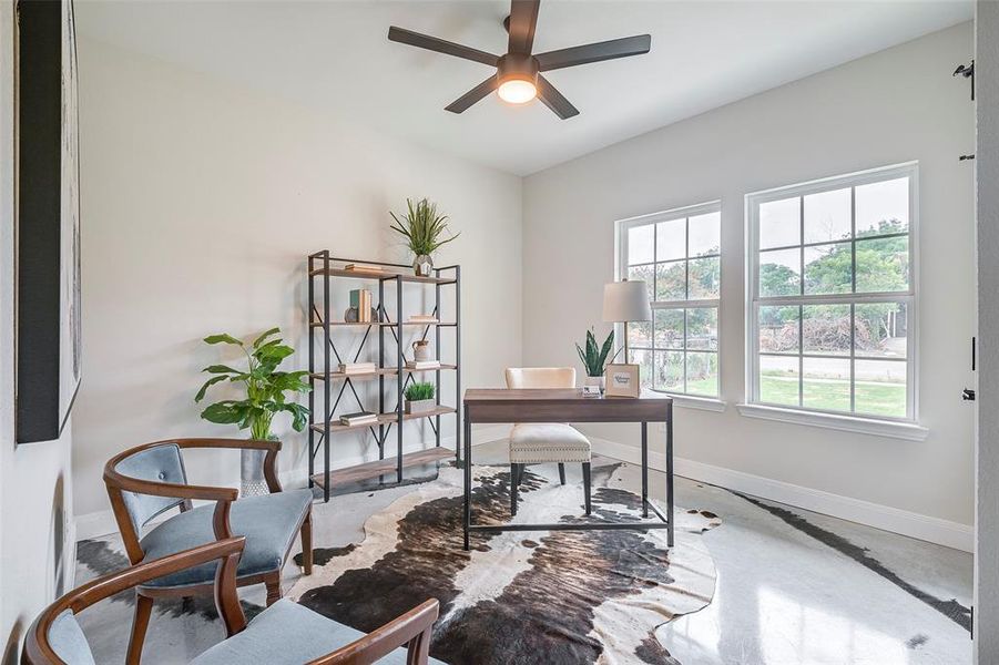 4th bedroom or Office area featuring a healthy amount of sunlight, concrete flooring, and ceiling fan