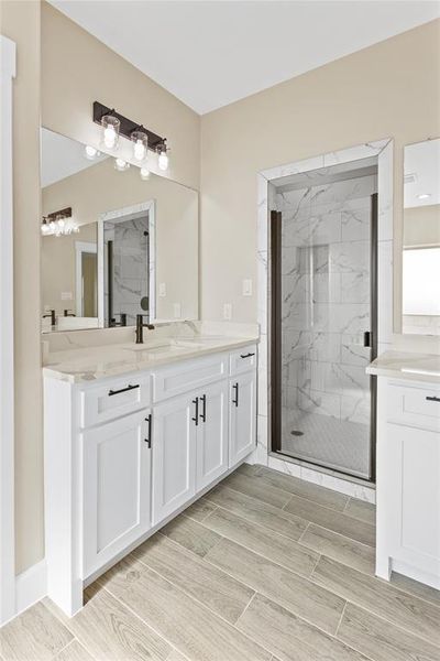 Bathroom featuring a shower with door and vanity