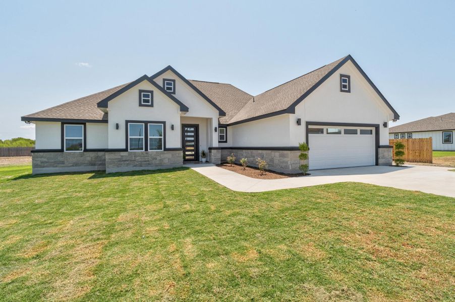 Modern farmhouse style home featuring stone siding, stucco siding, roof with shingles, and concrete driveway Modern farmhouse style home featuring stone siding, stucco siding, roof with shingles, and concrete driveway