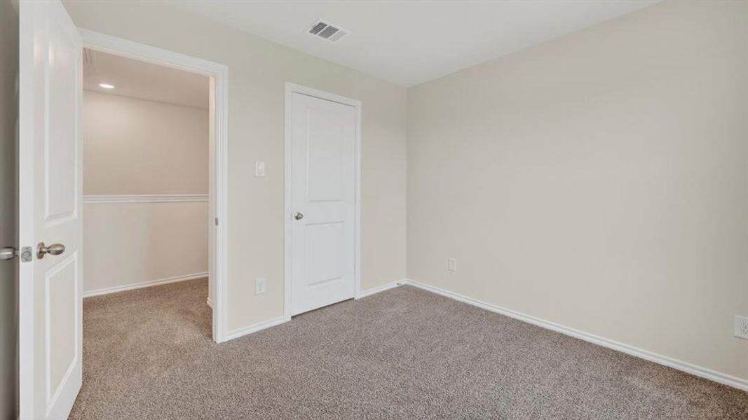 Carpeted room featuring light-colored walls, white trim, and a recessed ceiling light in the doorway