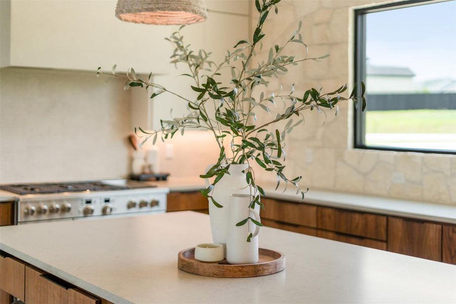 Kitchen view of light countertops and brown cabinets