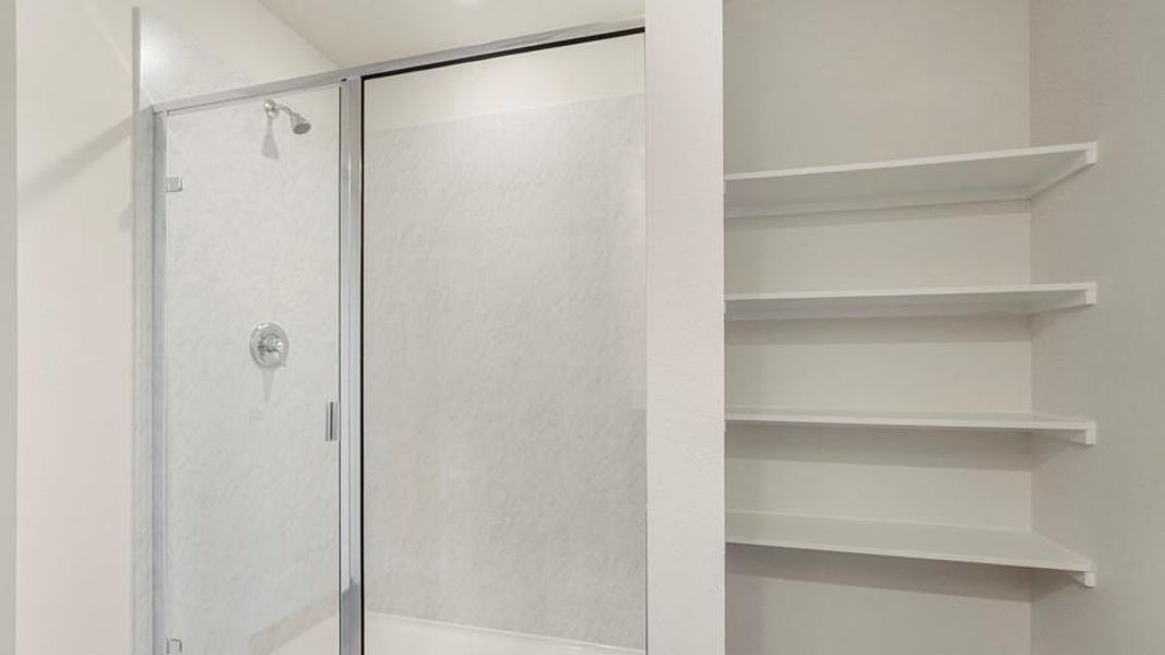 Shower enclosure featuring clear glass panels and a chrome shower head and fixtures