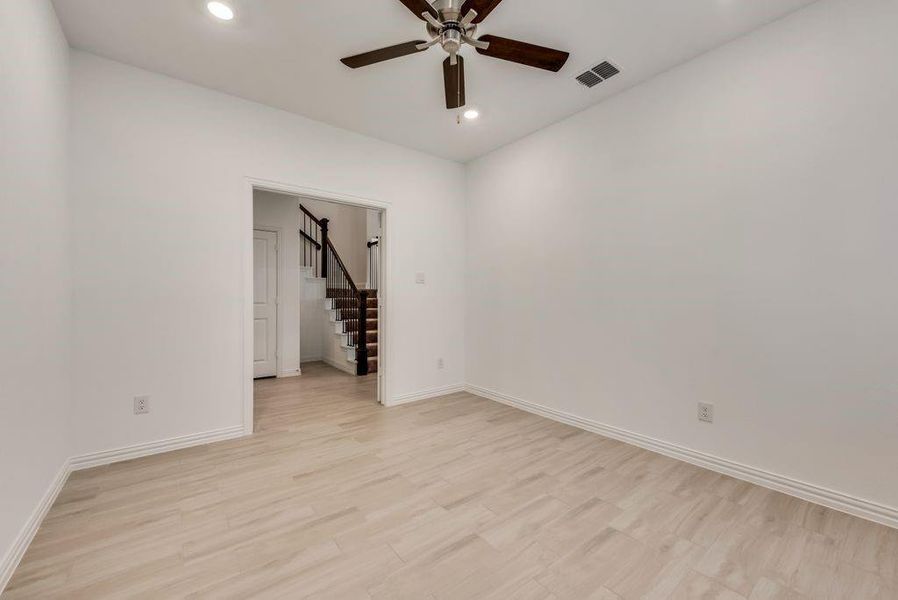 Empty room with ceiling fan and light wood-type flooring