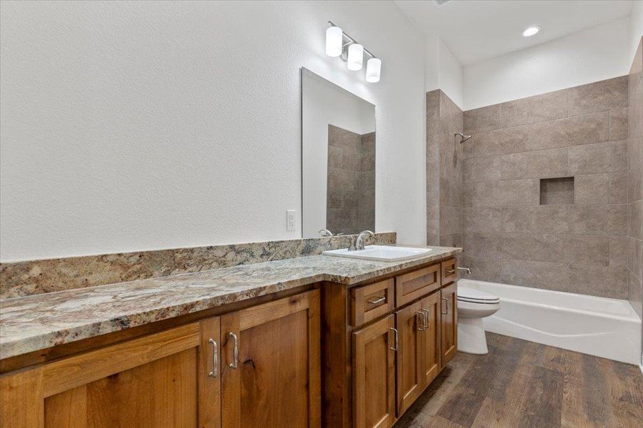 Bathroom with vanity,  shower combination, and wood finished floors