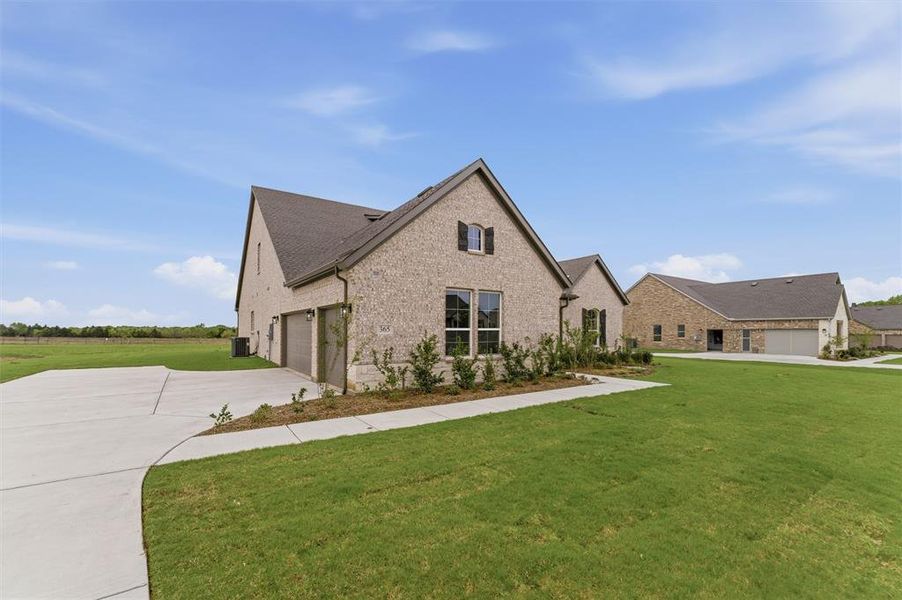 View of front of house featuring a front yard, brick siding, and concrete driveway