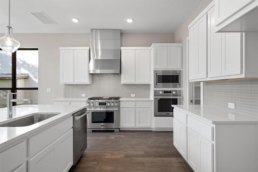 Culinary delights await in this bright kitchen with stainless steel appliances and abundant counter space. Culinary delights await in this bright kitchen with stainless steel appliances and abundant counter space.