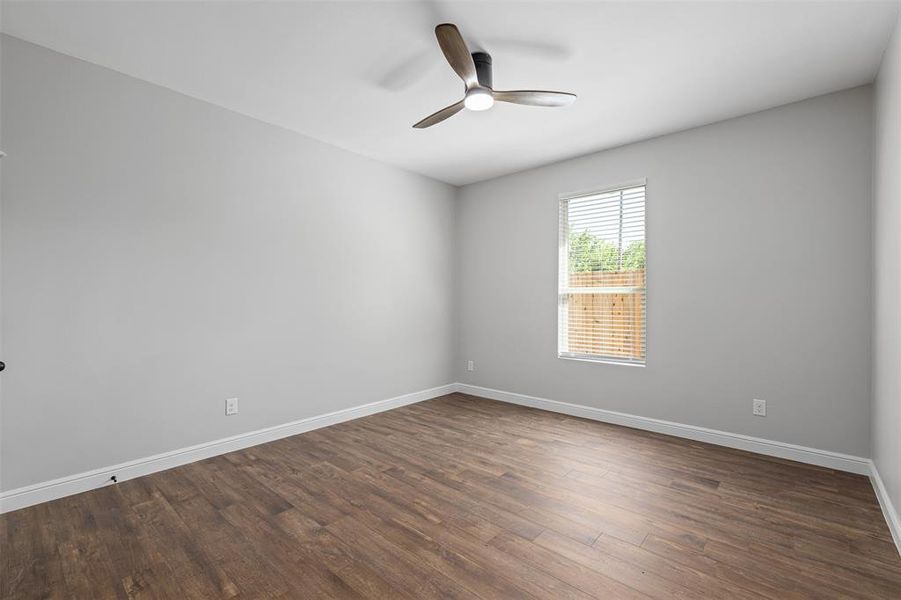 Unfurnished room with ceiling fan and dark hardwood / wood-style flooring