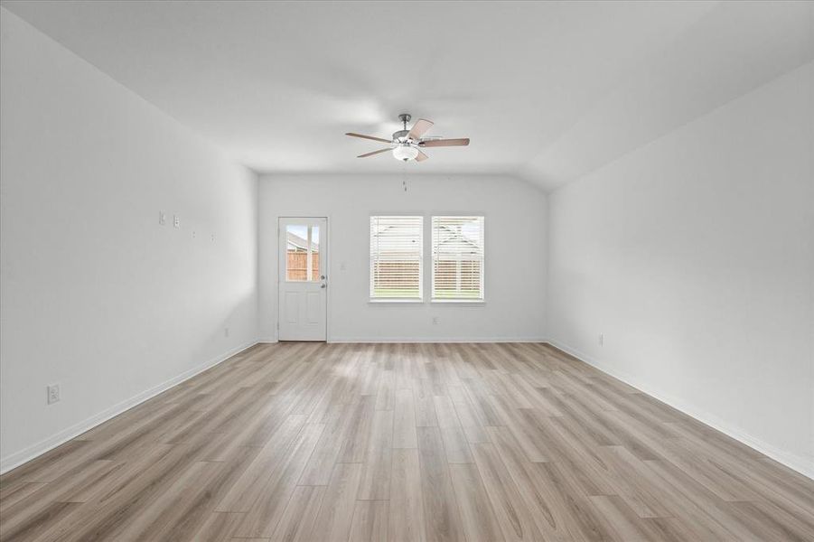 Unfurnished room with light hardwood / wood-style floors, lofted ceiling, and ceiling fan