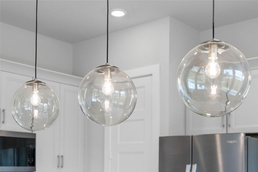 Atwell pendant light fixtures located over the kitchen countertop gives added light into the kitchen - adding a sleek, reflective accen Atwell pendant light fixtures located over the kitchen countertop gives added light into the kitchen - adding a sleek, reflective accen