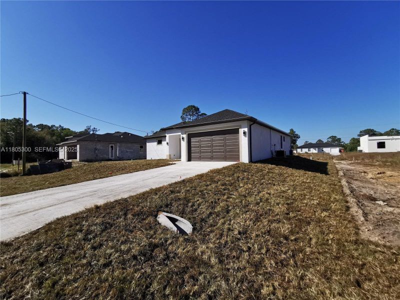 Front exterior of a new home in , Lehigh Acres, FL, highlighting curb appeal (Image 19).