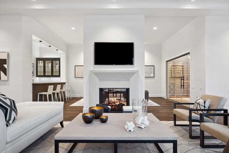 Double sided fireplace connects the living room with the flexible space open to the wet bar and wine room.